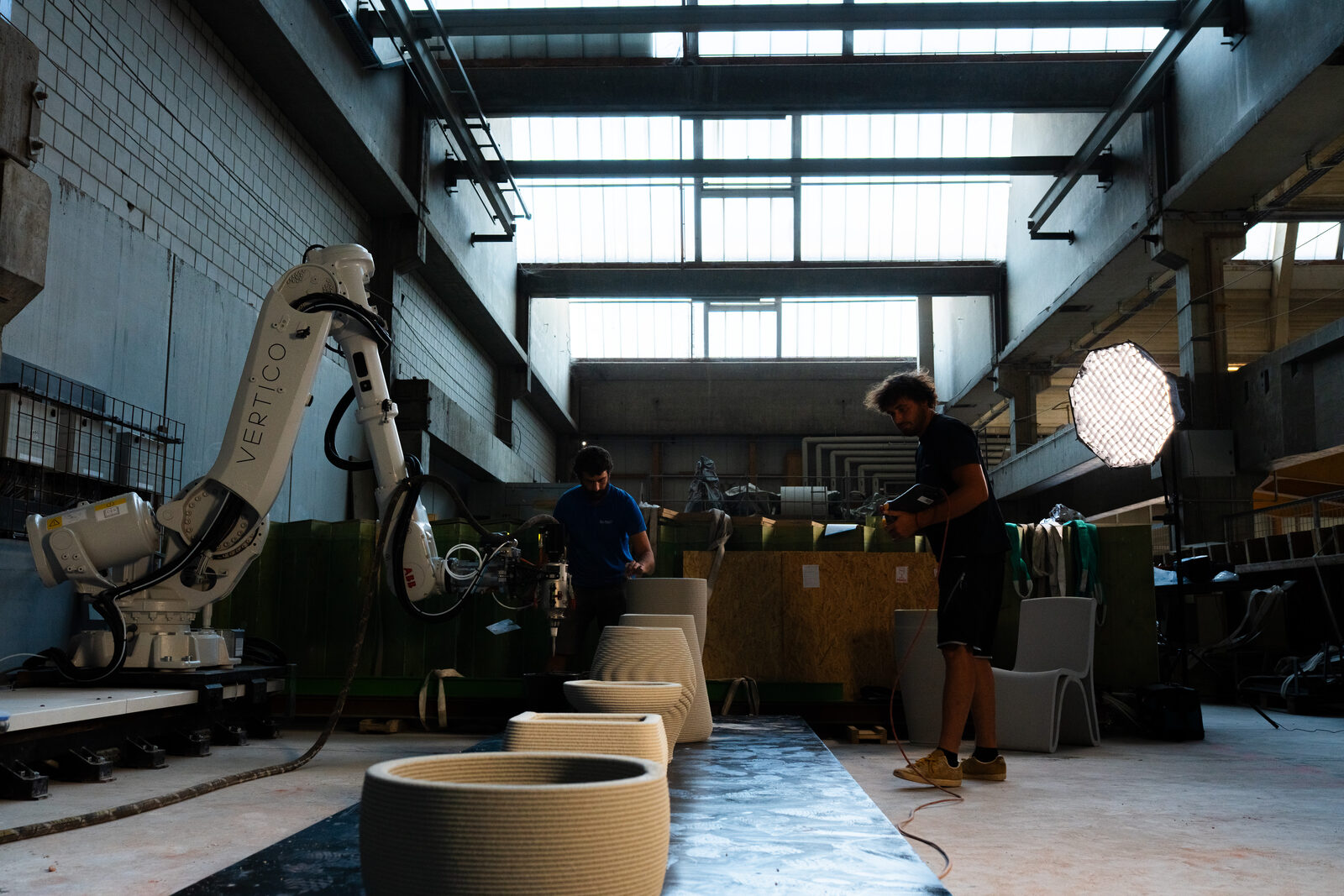 Die Halle im Gegenlicht mit Roboter und gedruckten Bauteilen