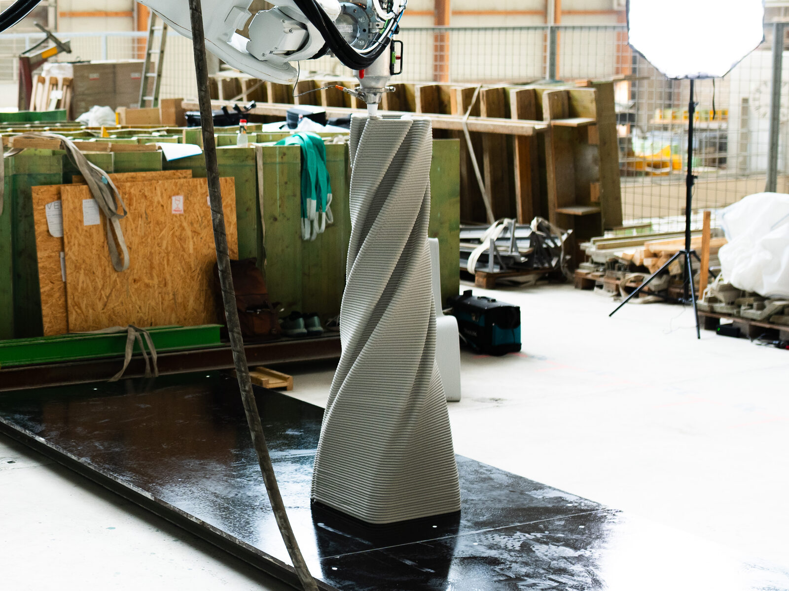 In sich gedrehte, gedruckte Betonsäule auf dem Druckbett, darüber der Druckkopf